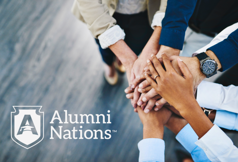 People placing hands on top of one another as if coming together as a team ready to start working towards a goal. Alumni Nations logo is present in the bottom left of the photo.