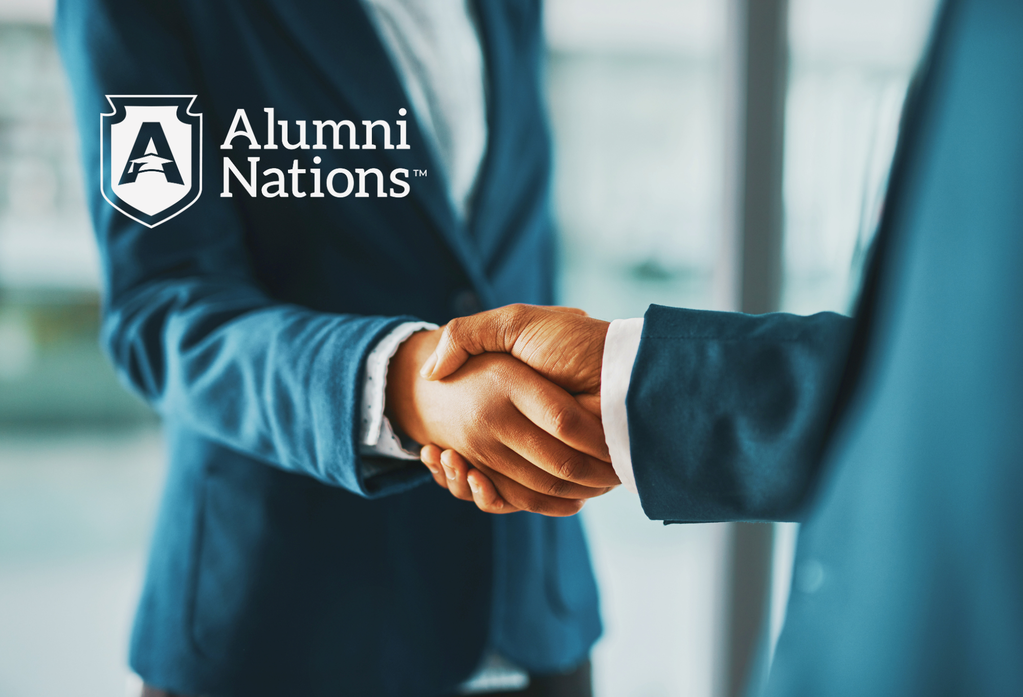 Two people dressed in suits are shaking each others hands. The Alumni Nations Logo is displayed on the top left of the photo.