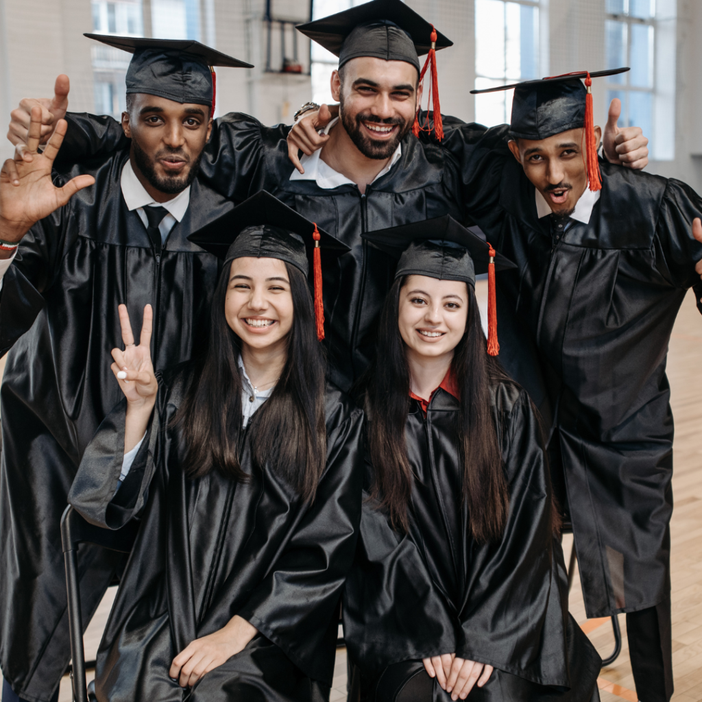 five people dressed in graduation clothing smiling for a photo.