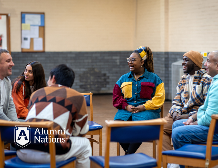 adults sits in a circle during a school alumni gathering, engaging in conversation and reconnecting as part of a K12 alumni engagement event.