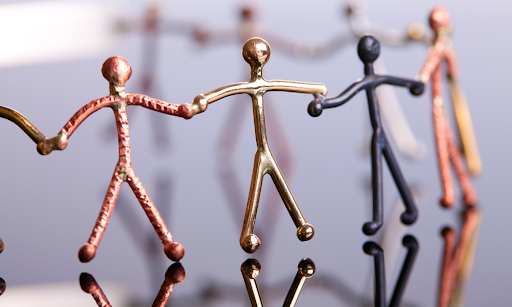 metal figures holding each other's hands representing connection in a community