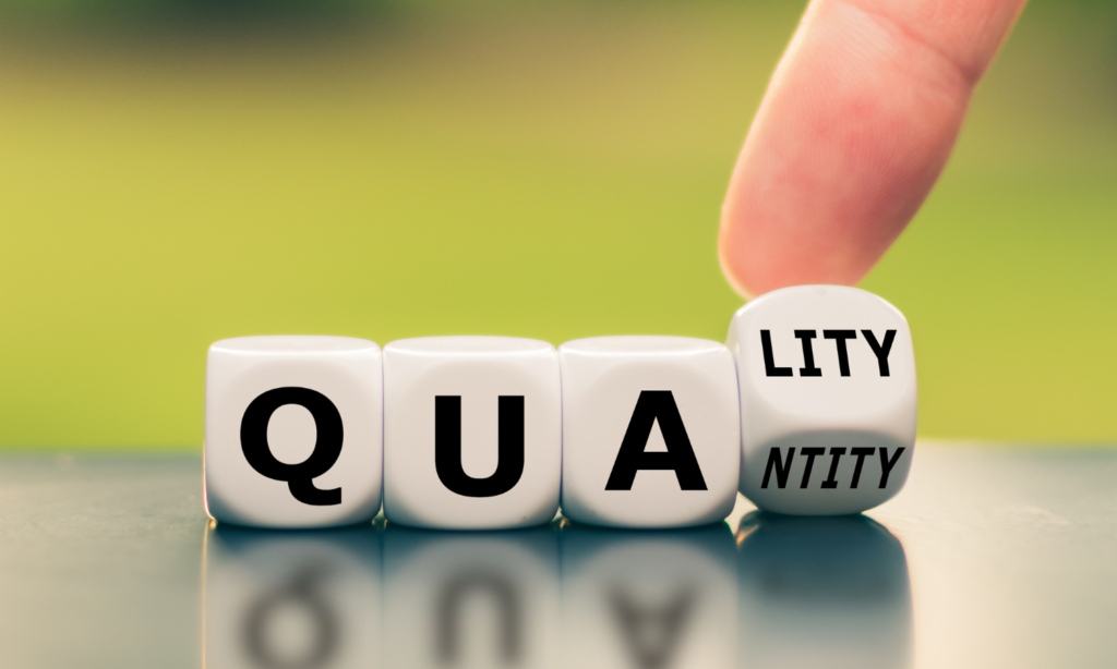 Close-up of dice spelling 'quality' with the option to change to 'quantity,' symbolizing the idea that impactful alumni engagement comes from quality connections over large numbers.
