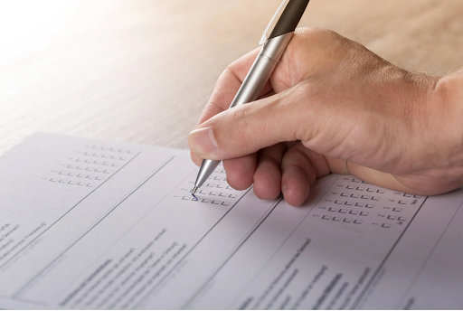 Someone filing out an alumni survey on a table