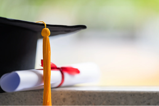 Graduation cap on a school desk representing alumni giving and high school milestones.