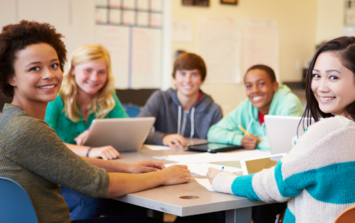 Alumni volunteers mentoring high school students during a college prep session