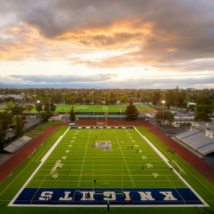 A high school football field with students playing