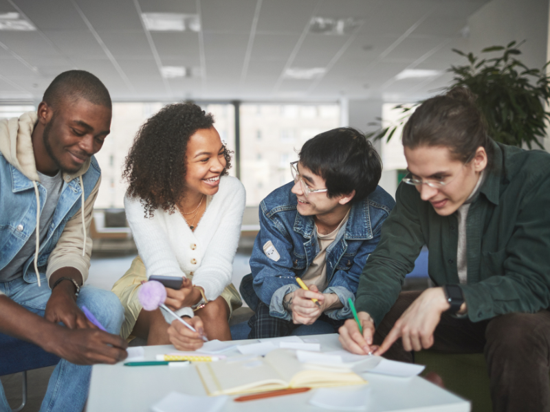 Group of alumni mentors and students standing together after a mentorship workshop.