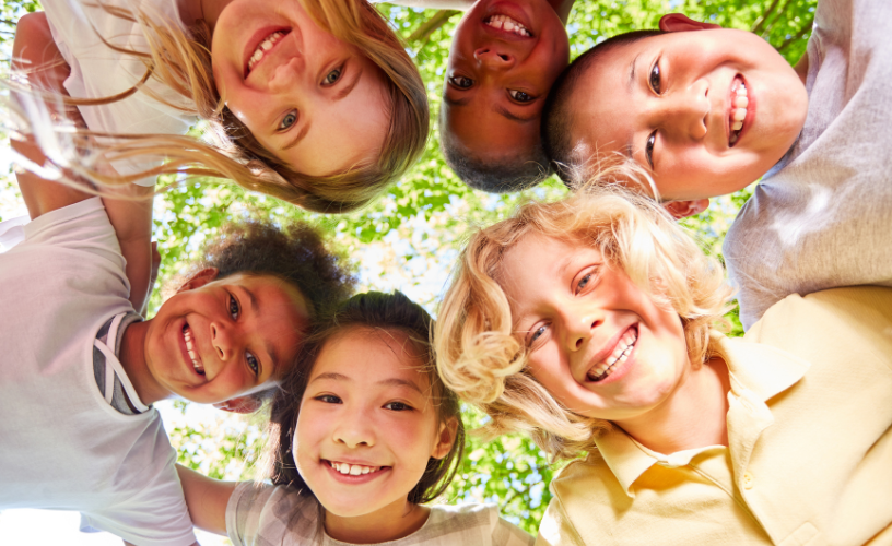 Five children in a circle smiling