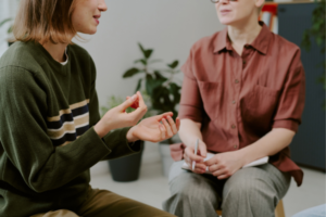 Group of kids in a circle in a library meeting with an adult.
