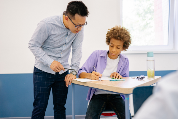 Teacher mentoring a student in the classroom, highlighting the formative relationships alumni remember