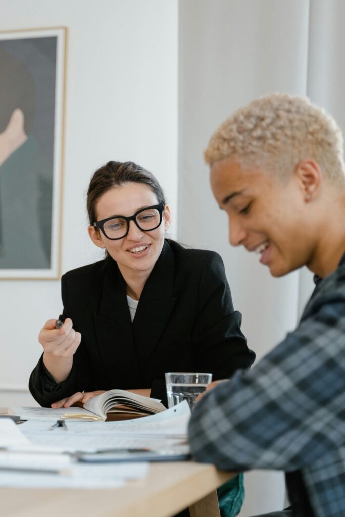 Alt text: An alumni mentor and a young graduate have a professional career conversation in a casual  setting 