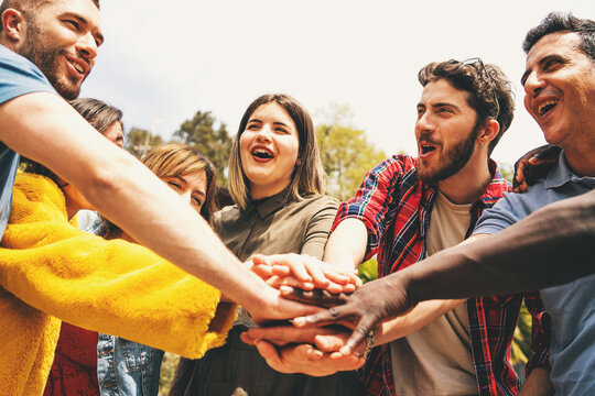 Group of people joining hands in celebration