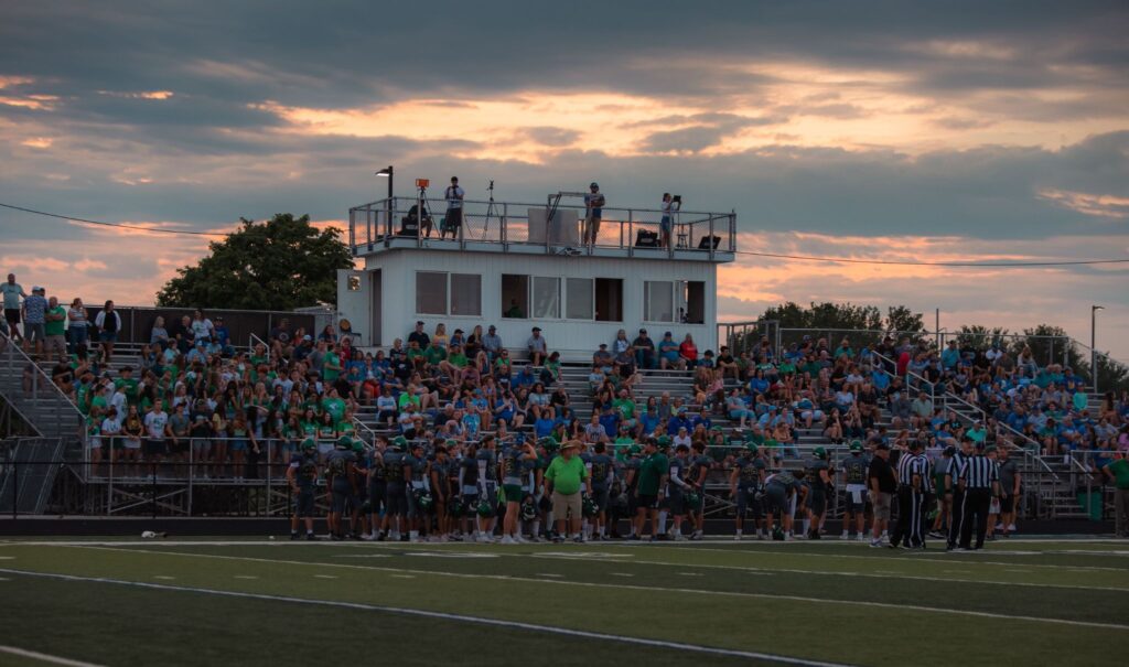 Fans increasing K12 alumni engagement during a local high school football game.
