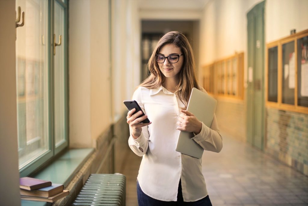 A person reading the school newsletter on her phone